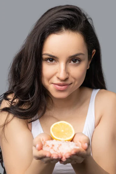 Hermosa chica morena sosteniendo una naranja en sus manos — Foto de Stock