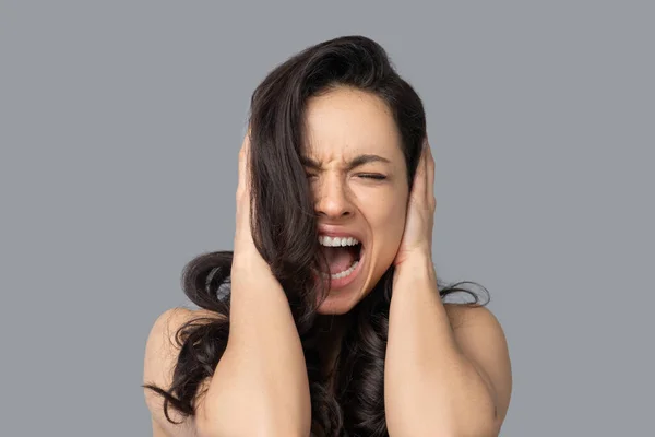 Beautiful dark-haired girl in a white top shouting — Stock Photo, Image