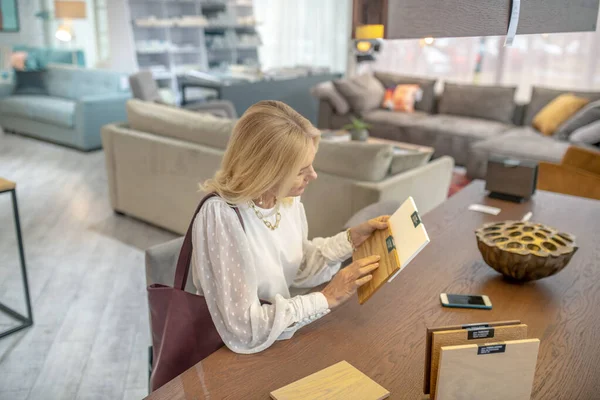 Mujer sosteniendo muestras de madera en sus manos para muebles . — Foto de Stock