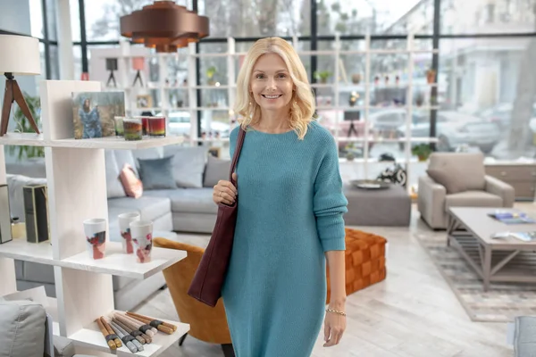 Gelukkige vrouw wandelen in de meubelsalon. — Stockfoto