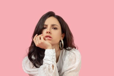 Beyaz bluzlu güzel esmer kadın bunalımlı görünüyor.