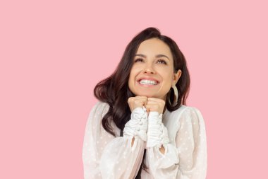 Beyaz bluzlu genç kadın rüya gibi görünüyor.