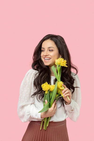 Joven mujer bastante morena sosteniendo flores amarillas —  Fotos de Stock