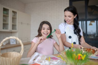 Kurdele tutan tatlı bir kız ve mutlu bir şekilde gülümsüyor.