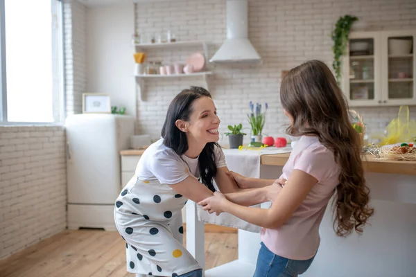 Brunette vrouw en haar schattige dochter glimlachen hebben plezier in de keuken — Stockfoto