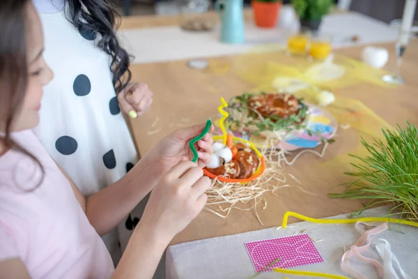 Immagine di panini pasquali in piedi sul tavolo e le mani delle ragazze decorazione — Foto Stock