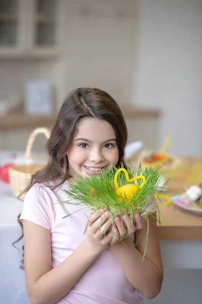 Красивая улыбающаяся девушка держит в руках пасхальные украшения — стоковое фото