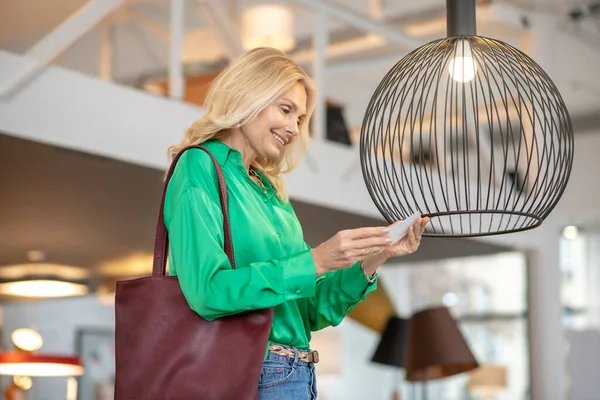 Blonde Frau in grüner Bluse schaut den Vogel an — Stockfoto