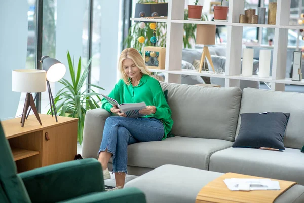 Mujer rubia en una blusa verde buscando involucrado — Foto de Stock