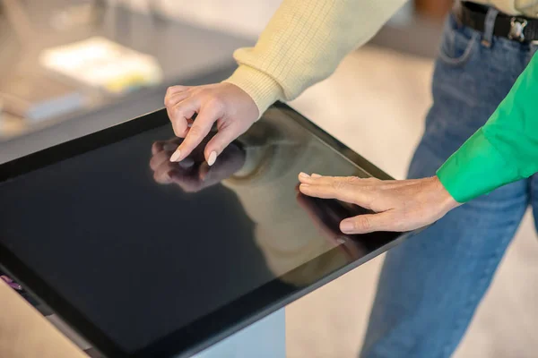 Weibliche Hände berühren Finger auf dem Bildschirm des Geräts. — Stockfoto