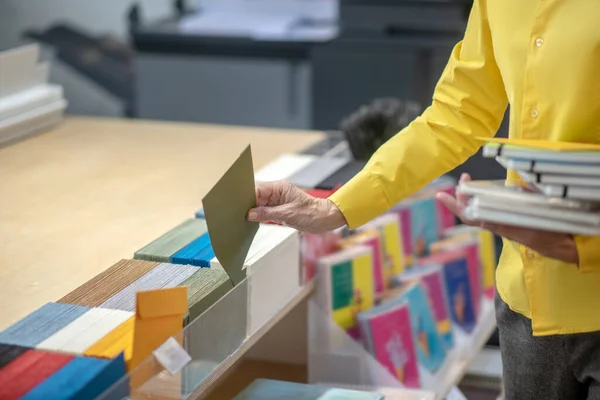 Vrouwelijke handen die enveloppen uitdelen, notitieboekjes vasthouden — Stockfoto