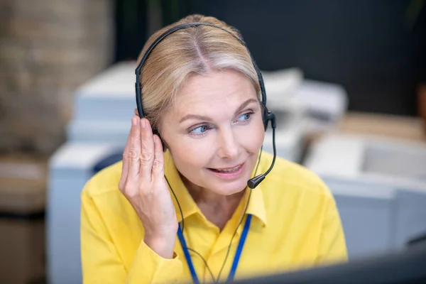 Blonde woman sitting in headphones and talking — Stock Photo, Image