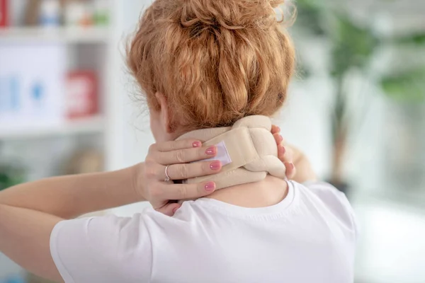 Vrouwelijke patiëntenhanden houden beige nekverband vast — Stockfoto
