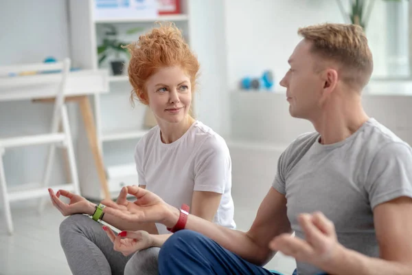 Female patient and male physiotherapist sitting in lotus position — Stock Photo, Image