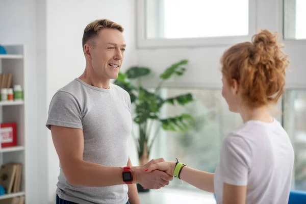 Patient féminin et physiothérapeutes masculins se serrant la main — Photo