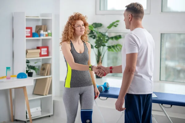 Male physiotherapist and female patient shaking hands, greeting each other — Stock Photo, Image