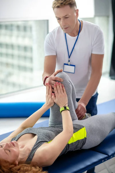 Férfi fizioterapeuta női beteg térdsérülésének kezelésében — Stock Fotó