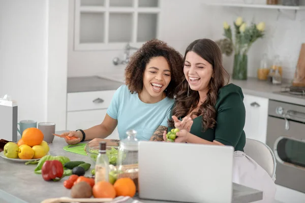 Two girlfriends sitting at a table in the kitchen. — Stock Photo, Image