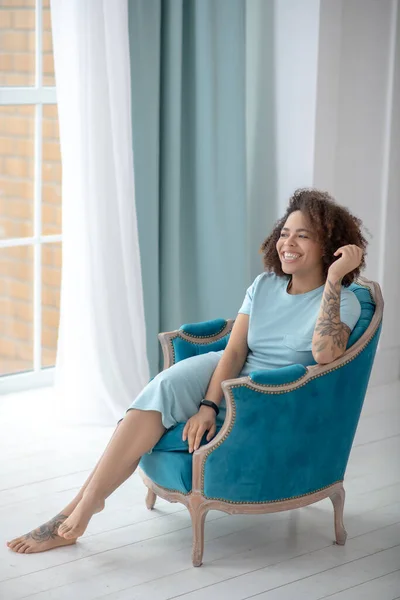 Elegante bella donna con tatuaggi seduta su una sedia . — Foto Stock
