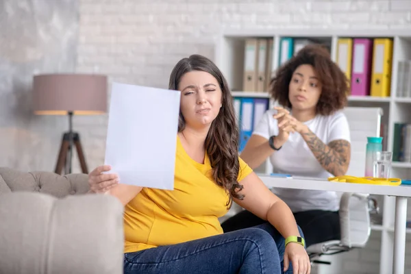 Bir beslenme uzmanının resepsiyonunda oturan tatminsiz kadın.. — Stok fotoğraf