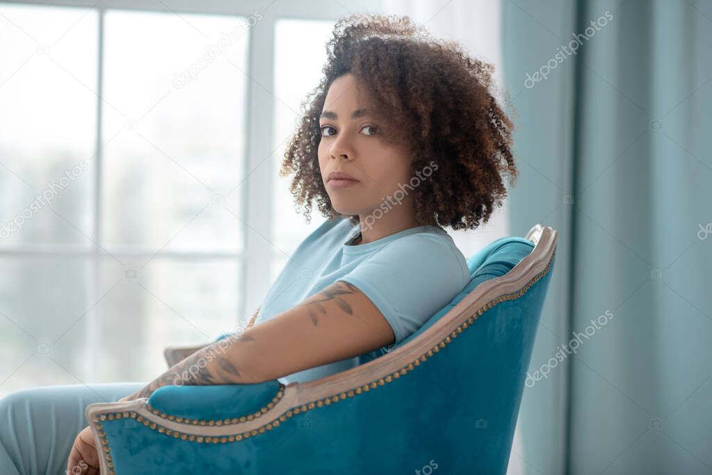 Woman sitting in the armachair looking thoughtful
