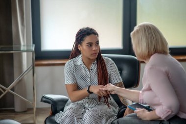 Genç bir kadın terapi seansı yapıyor ve stres altında.