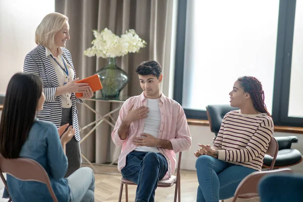 Rubia psicóloga en una blusa rosa hablando con los pacientes — Foto de Stock