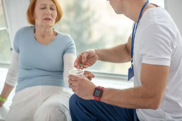 Профессиональный молодой врач дает таблетки своему пациенту — стоковое фото