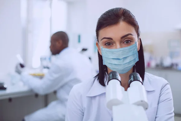 Alert young female bioengineer wearing a mask — Stock Photo, Image