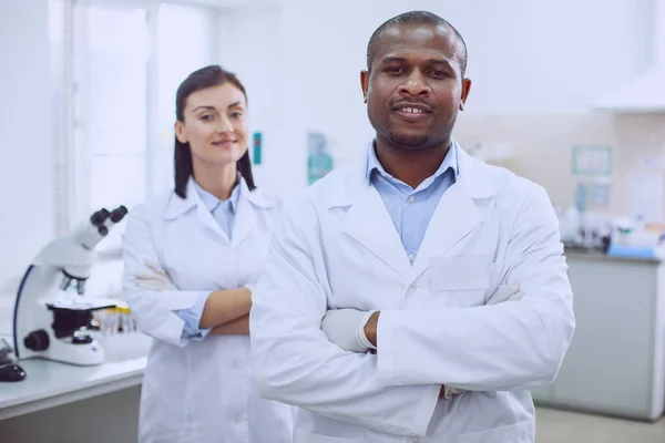 Biólogos alegres de pie juntos en el laboratorio —  Fotos de Stock