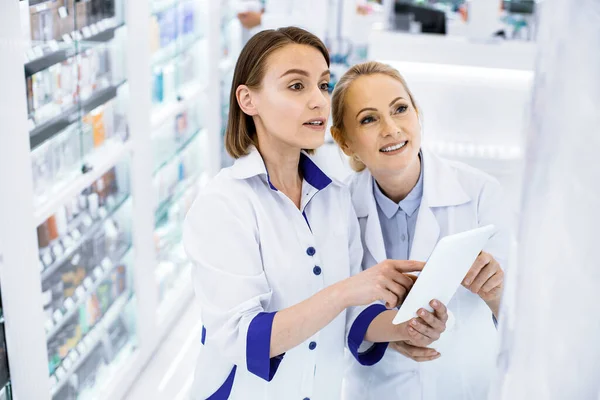 Duas mulheres farmacêuticos em pé em uma farmácia . — Fotografia de Stock