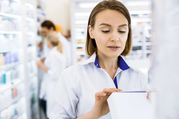 Farmacêutica feminina grave estudando a composição da droga . — Fotografia de Stock