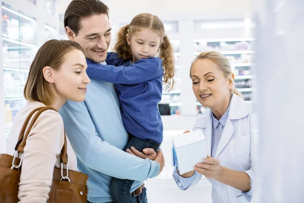 Loira profissional farmacêutico feminino ajudando a família jovem — Fotografia de Stock