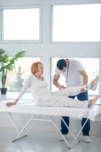 Paciente idoso agradável sentado na cama médica — Fotografia de Stock