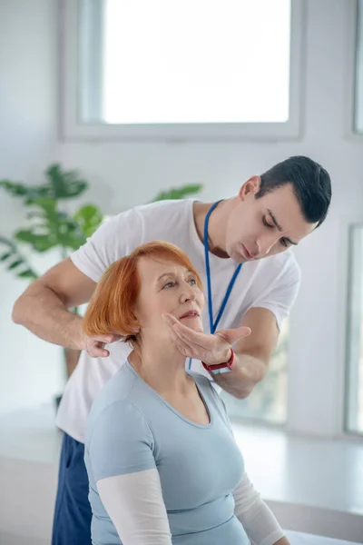 Nice serious man touching his patients chin — Stock Photo, Image