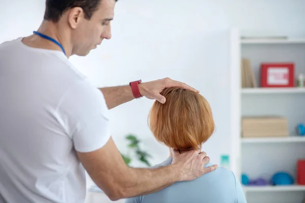 Zkušený mladý lékař dotýká jeho pacienti hlavu — Stock fotografie