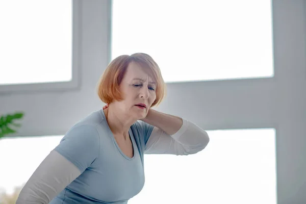 Triste femme âgée souffrant de douleur dans ses muscles — Photo