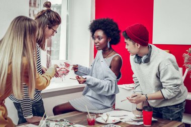 Yaratıcı eskizini sergileyen koyu tenli güzel bir kız.