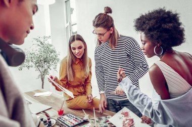 Ciddi esmer kız yarı pozisyonda duruyor.