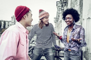 Balkonda duran neşeli genç insanlar.