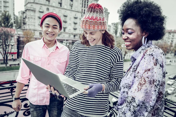 Schöne junge männliche Person zeigt seinen Laptop — Stockfoto