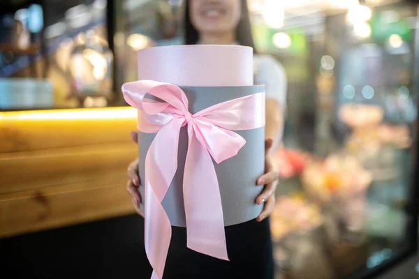 Assistante de magasin brune tenant une boîte-cadeau — Photo