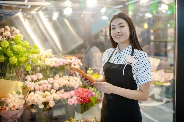 Dai capelli scuri asiatico fiore negozio assistente cercando premuroso — Foto Stock