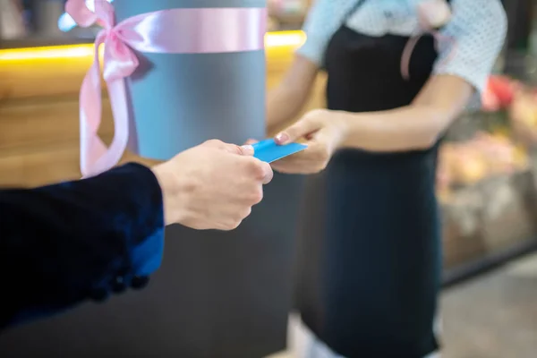 Mans mano pasando la tarjeta de crédito al asistente sho — Foto de Stock