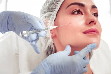 Kadın kendini sakin hissediyor. Temizlendikten sonra güzellik iğnesi yaptırıyor.