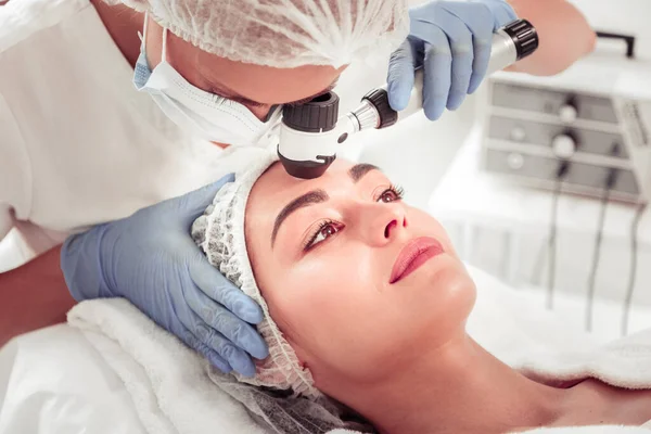 Cosmetoloog schoonmaken van de huid van de klant met behulp van nieuwe apparatuur — Stockfoto