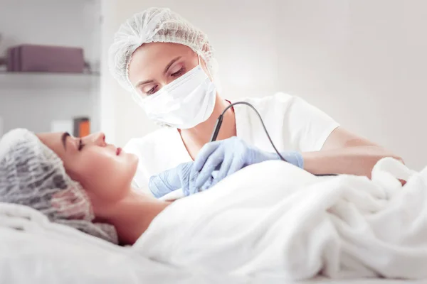 Güzellik uzmanı yeni ultrason cihazıyla yüzünü temizliyor. — Stok fotoğraf