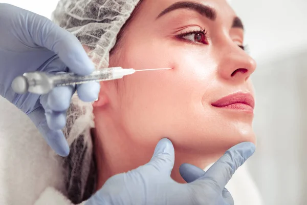 Kosmetolog vidröra ansikte klient gör skönhet skott — Stockfoto