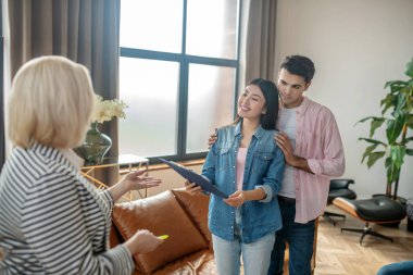 Koyu saçlı uzun adam ve kız arkadaşı kabinedeki psikologla konuşuyorlar.