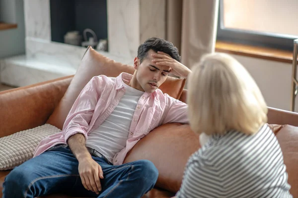 Joven con una camisa rosa buscando angustiado — Foto de Stock